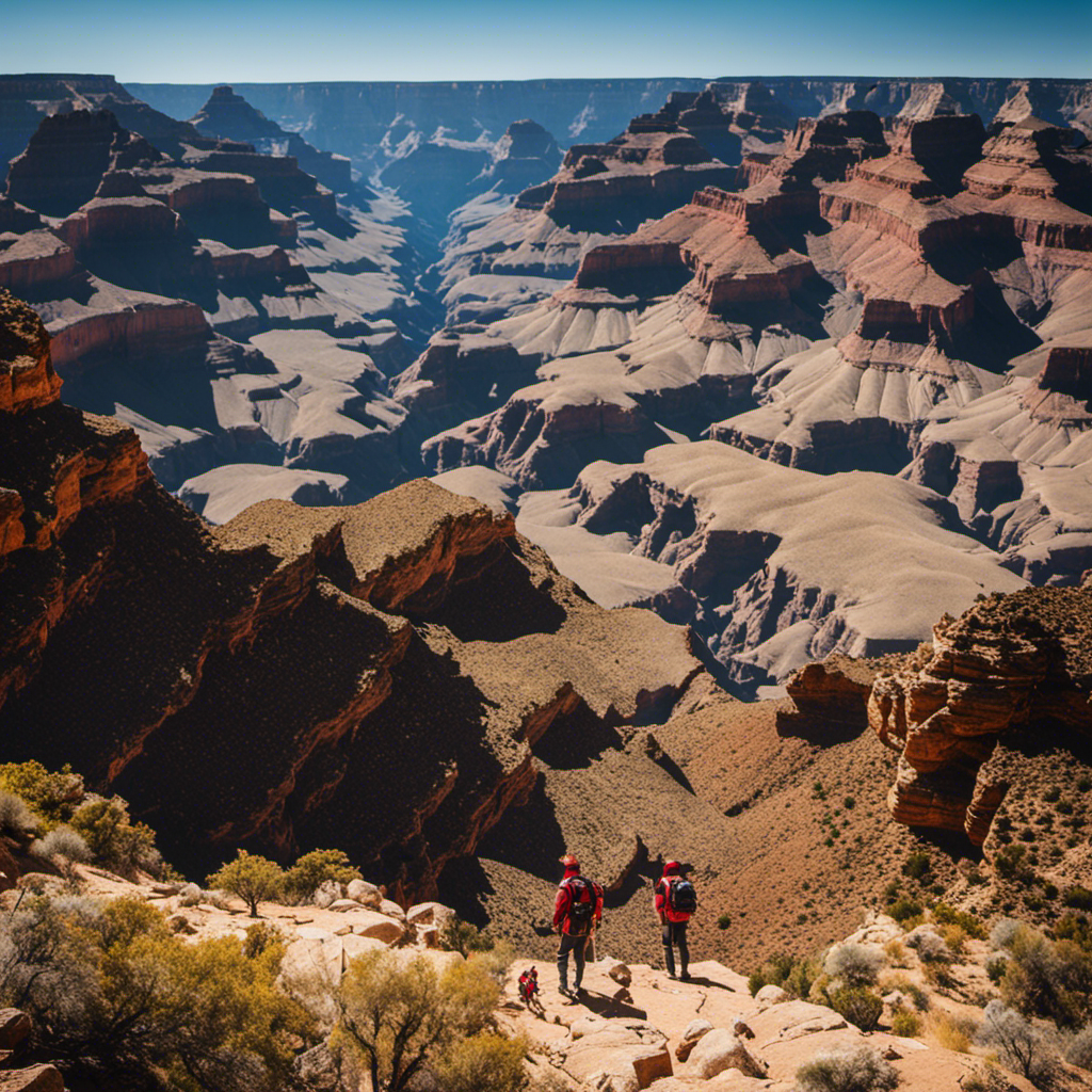 An image showcasing the awe-inspiring size of the Grand Canyon, with the vibrant orange and red rock formations towering high against the clear blue sky, while tiny hikers explore its vastness